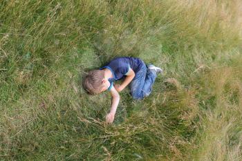 Handsome boy sleeping on meadow grass