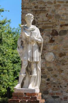 Marble statue of St. Damian at the entrance to the parish of Cosmas and Domian, Grazzano Visconti, Italy