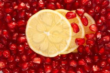 Royalty Free Photo of Lemon Slices on Pomegranate Seeds Background