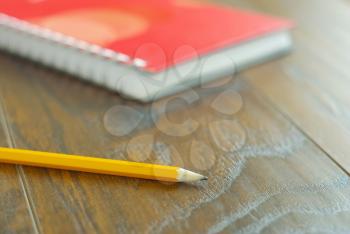 Pencil on table with notebook background. Diary organizer office stationary closeup. Memories reminder idea.
