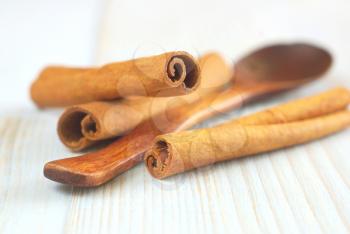 Cinnamon sticks with wooden spoon old style retro background. Selective focus. 