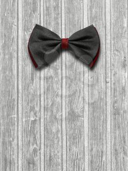 Black and red bow tie on a light wooden background