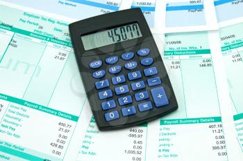 Royalty Free Photo of a Calculator on Payroll Documents