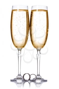 Two glasses of champagne with wedding rings. 