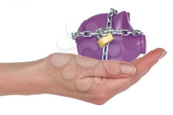 Piggy-bank secured with padlock and chain in a hand. Isolated on white background