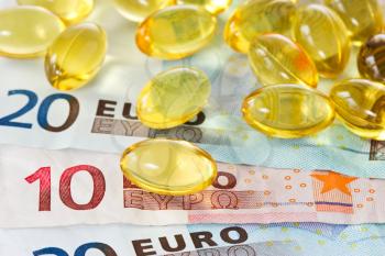 medical expenses concept. yellow pills and euro currency