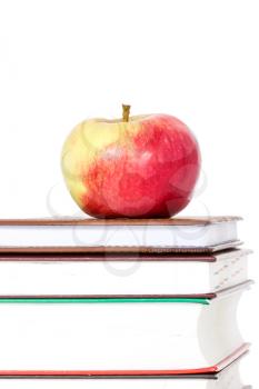 Stack of books with red apple on top over white background