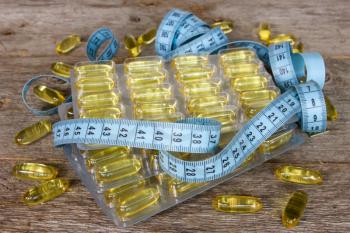 Royalty Free Photo of Fish Oil Capsules and Measuring Tape