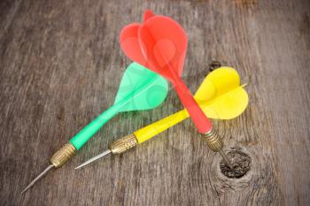Three color darts  on a wooden background