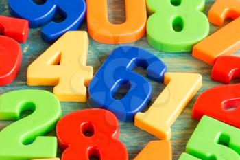 Colorful plastic numbers on a painted wooden background