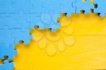 Puzzle on yellow wooden background.Team business concept