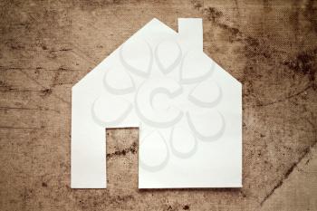 Paper house icon on dirty canvas background
