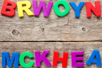Old wooden background with multicolored toy letters