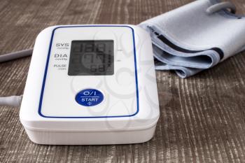 Digital blood pressure monitor on wooden table