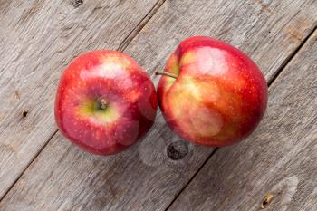 Red apples on wooden background, top view.
