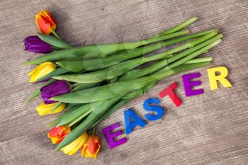 Lettering EASTER and bouquet of colorful tulips 