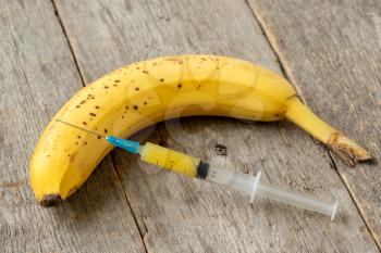 Syringe and banana. Concept for genetically modified food and cosmetic medicine