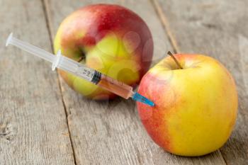 Syringe in apple. Concept for genetically modified food and cosmetic medicine