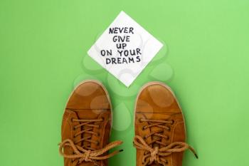 Never Give Up On Your Dreams - handwriting on a napkin with a brown sneakers
