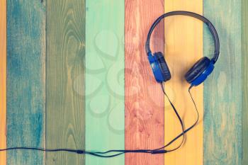 Headphones on colored wooden background with copy-space