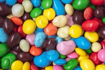 Colorful sweets background. Nuts in multi-colored glaze dragee. Pile of colorful coated candy.