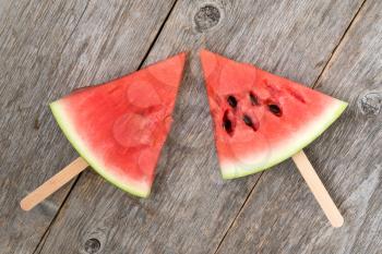 Watermelon slice popsicles on a old wood background