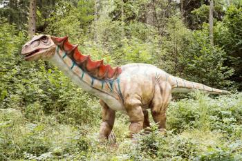 Gigantic statue of realistic dinosaur in a forest