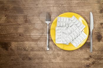 Pills ,drugs ,tablets,pharmaceutical on plate with fork and knife 