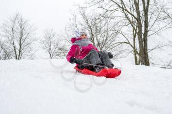 Girl enjoying a sleigh ride, play outdoors in snow.