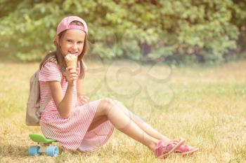 Girl eat ice cream while sits on skateboard