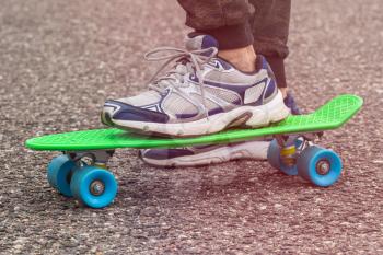Closeup of skateboarder legs. Boy ride skateboard on a city street.