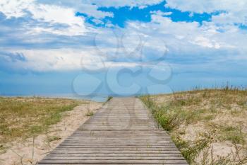 Wooden path over sand dunes with sea view
