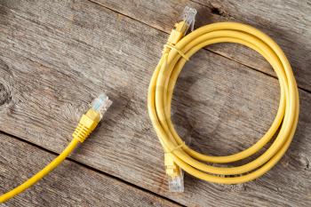 Yellow network cables on the old wooden background