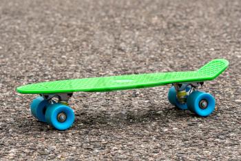 Green skateboard on the asphalt road