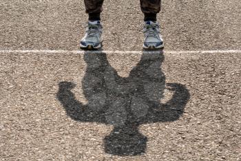 Shadow of man on a stadium running path. Sport concept