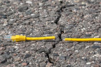 Cuted internet cable is divided by crack in asphalt road. Internet censorship concept