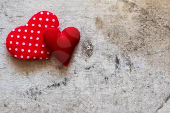  Two cute red hearts on the old canvas background. Copy space.