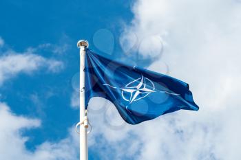 NATO flag waving in the wind against sky background