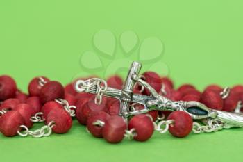 Close-up of christian rosary on green background