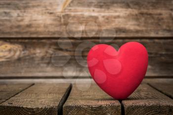 Red heart on the weathered wooden background. Love and romance