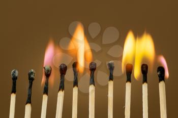 Close-up view of a match sticks burning with a bright colorful flames