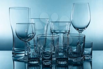 Set of different empty glasses on blue background