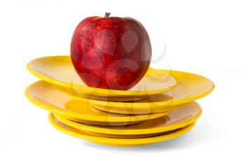Yellow dinner plates and red apple on top. Isolated on white background.