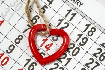 Memorable cute heart pendant on the February 14th monthly calendar. Valentine's day background