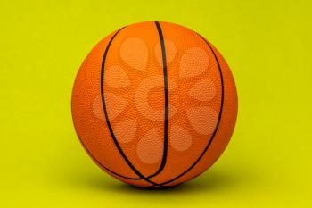 Orange basketball ball isolated on green background. Sport equipment.