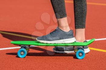 Skater rides on skateboard. Foot of skateboarder riding on penny board. Popular youth extreme sport