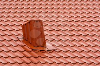 Modern red roof made of metal. Corrugated metal roof and metal roofing industry concept. Imitation of ceramic tiles roof.