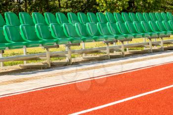 Running track and plastic chairs in a row on sports stadium