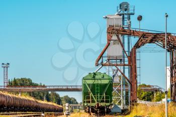 Loading railway wagon standing near the elevator in agriculture zone. Grain silo, warehouse or depository is an important part of harvesting.