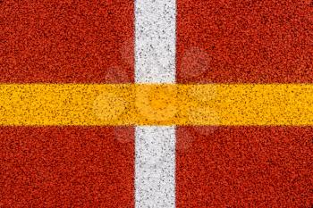 White and yellow crossed lines on the red stadium running track